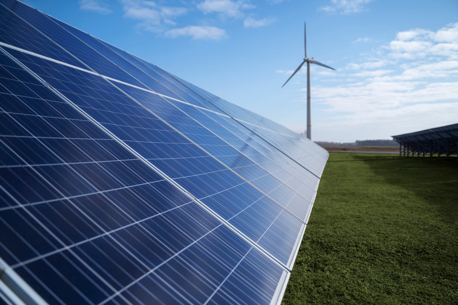 solar panel array with wind turbine in the green field